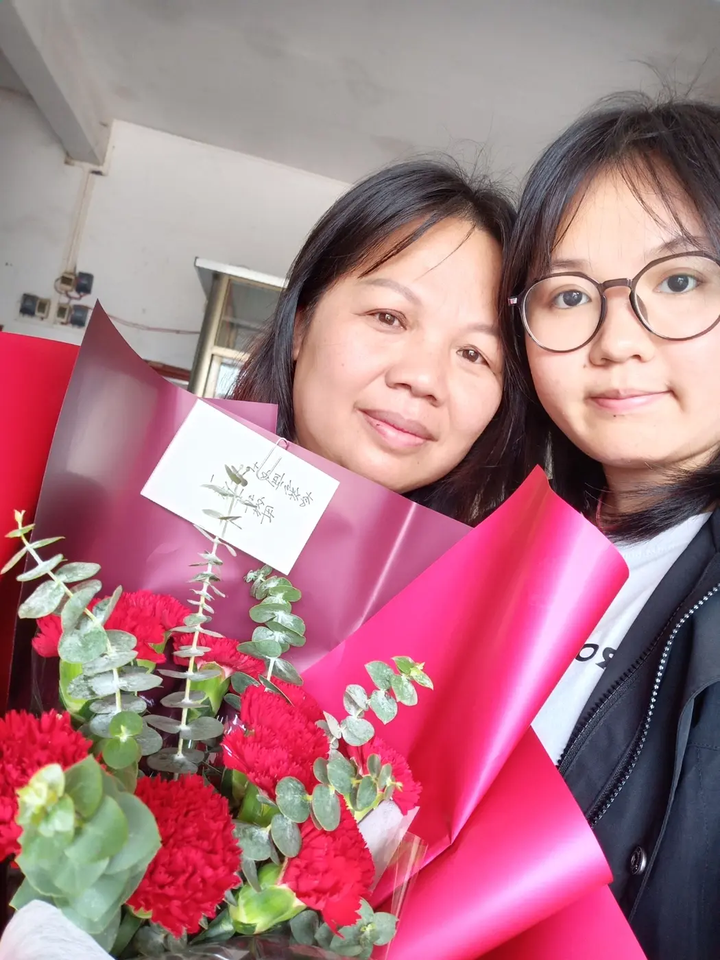 霞霞和妈咪一起抱着红色花束的合照